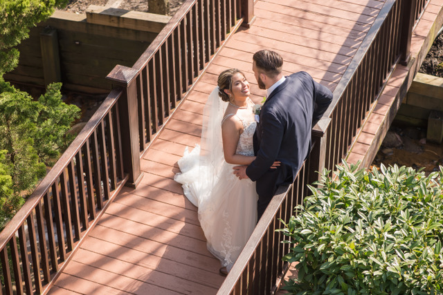 A married couple on a bridge in the daytime.